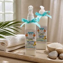 Two bottles of RDC Essentials Island Escape hand and body lotion on a wooden tray with a towel and stones in the background.