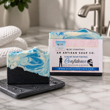 Two soaps with a branded box on a marble surface, with a bathroom setting in the background.