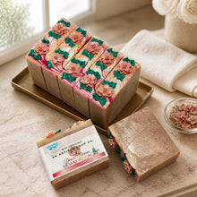 Decorative soap bars with floral designs on a marble surface, featuring a visible brand label.