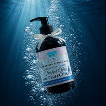 Bottle of R+Co 'The Perfect Man' shower gel and body wash underwater with sunlight filtering through.