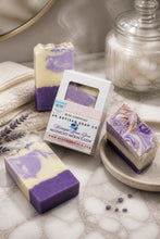 Purple and white soap bars with packaging on a marble surface