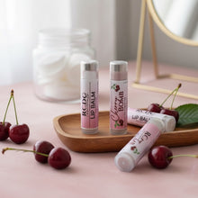 Three lip balms on a wooden tray with cherries and a mirror in the background