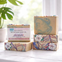 Stack of marbled soap bars with visible branding on a light surface.