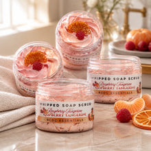 Jars of Raspberry Tangerine Whipped Soap Sugar Scrub with pink and orange hues, displayed alongside yellow tulips and decorative fruits on a white background.