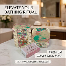Three decorative goat's milk soap bars with marbled pastel patterns and a pink boxed bar of soap are arranged on a marble bathroom counter, with text overlays reading 'ELEVATE YOUR BATHING RITUAL', 'PREMIUM GOAT'S MILK SOAP', and 'VISIT WWW.RCDCESSSENTIALS.