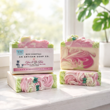 Three bars of pink and green soap with a box labeled 'RDC Essentials' on a white surface.