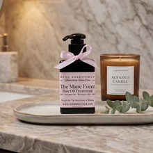 ACID ESSENTIALS The Mane Event Hair Oil Treatment in a black pump bottle with a pink ribbon, styled on a marble tray next to a scented candle on a marble countertop.
