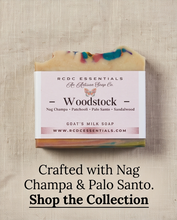 A rectangular bar of handmade soap labeled 'Woodstock' by RCDC Essentials, shown on a textured beige fabric background with promotional text below reading 'Crafted with Nag Champa & Palo Santo. Shop the Collection.
