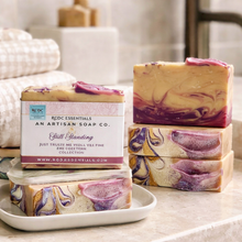 Artisan soap bars with marbled design and visible brand label on a white surface.